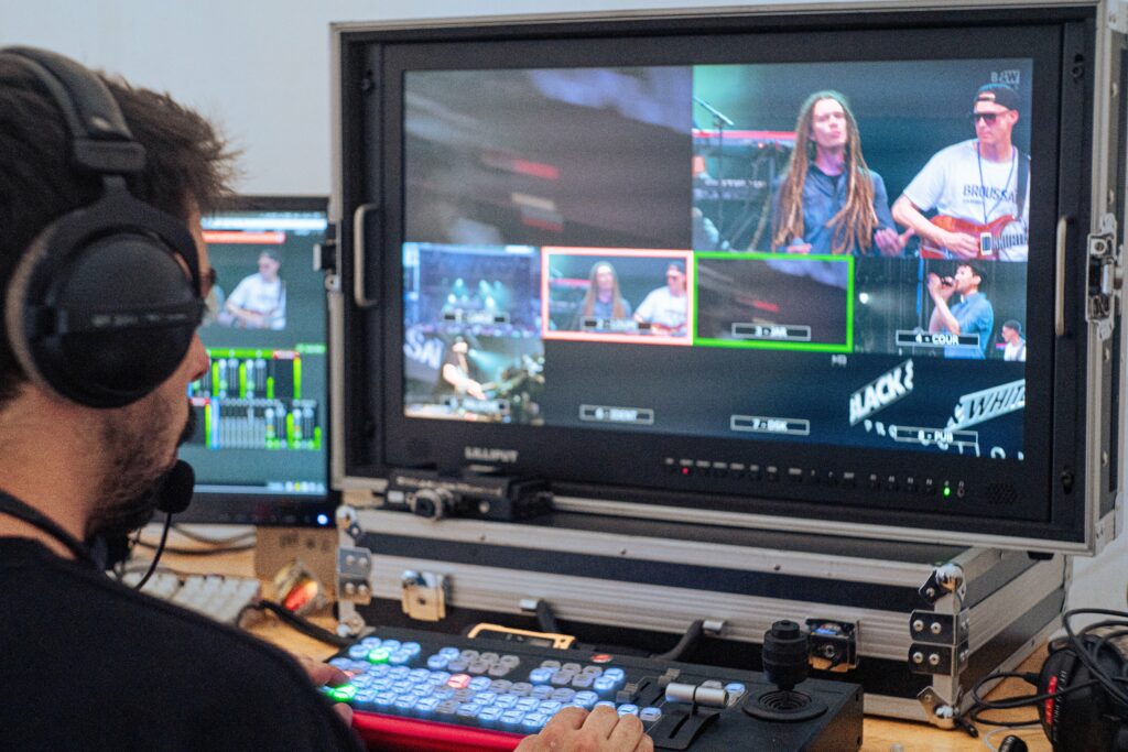 Un réalisateur devant un écran avec plusieurs angles de caméras.